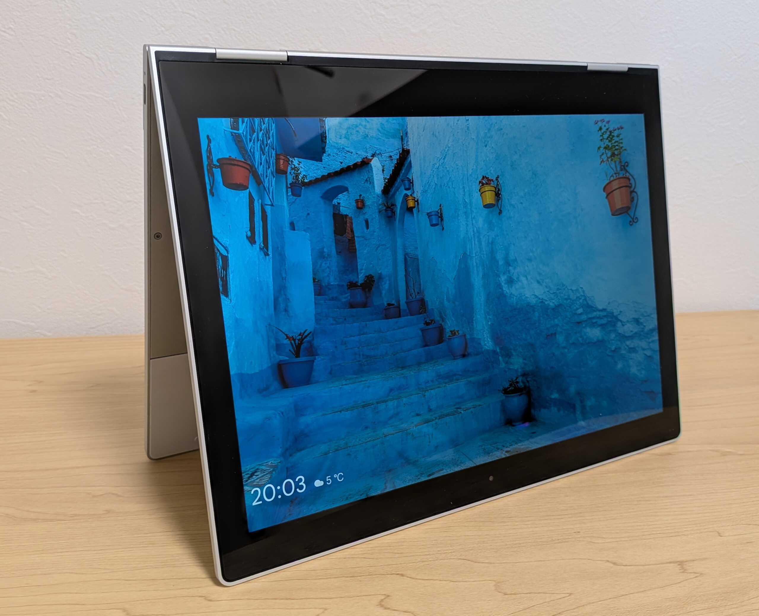 テントモードで自立し、美しい風景の壁紙を表示しているPixelbook